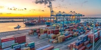 a container ship docked in a port at sunset