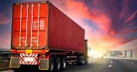 a red truck driving down a highway at sunset