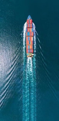 an aerial view of a container ship in the ocean