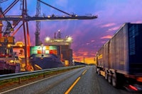 a truck is driving down a road with a container in the background